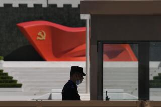 FILE - A security guard stands near a sculpture of the Chinese Communist Party flag at the Museum of the Communist Party of China on May 26, 2022, in Beijing. China said it was conducting military exercises Saturday, July 30, off its coast opposite Taiwan after warning Speaker Nancy Pelosi of the U.S. House of Representatives to scrap possible plans to visit the island democracy, which Beijing claims as part of its territory. (AP Photo/Ng Han Guan, File)