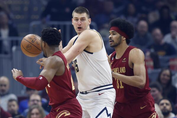 Denver Nuggets center Nikola Jokic (15) is defended by Cleveland Cavaliers center Jarrett Allen (31) and guard Donovan Mitchell during the first half of an NBA basketball game Thursday, Feb. 23, 2023, in Cleveland. (AP Photo/Ron Schwane)
