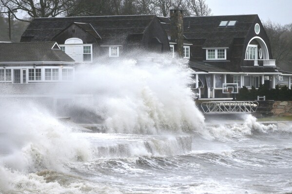 High winds drive surf into a retaining wall in front of a residence in Mattapoisett, Mass. on Monday, Dec. 18, 2023 as a storm makes its away across the region. (Peter Pereira/The Standard-Times via AP)