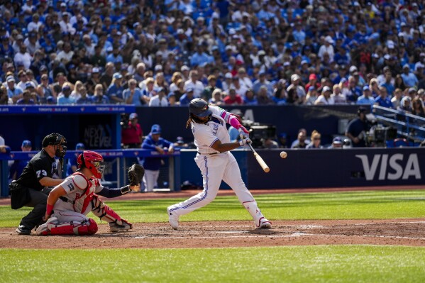 Toronto Blue Jays' Vladimir Guerrero Jr. (27) hits a single against the Boston Red Sox during the sixth inning of a baseball game in Toronto, Sunday, Sept. 17, 2023. (Andrew Lahodynskyj/The Canadian Press via AP)