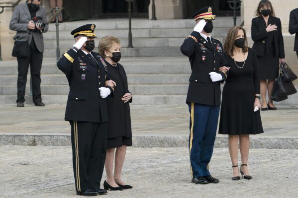 Former Sen. Elizabeth Dole, second from left, accompanied by Chairman of the Joint Chiefs Gen. Mark Milley, left, and Robin Dole, right, watch as the flag-draped casket of former Sen. Bob Dole of Kansas, is carried from the Washington National Cathedral following a funeral service, Friday, Dec. 10, 2021, in Washington. (AP Photo/Manuel Balce Ceneta)