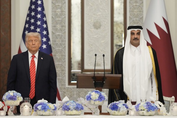 President Donald Trump and Qatar's Emir Sheikh Tamim bin Hamad Al Thani stand during the U.S. national anthem at a state dinner at Lusail Palace in Doha, Qatar, Wednesday, May 14, 2025. (AP Photo/Alex Brandon)
