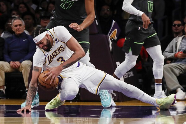Los Angeles Lakers forward-center Anthony Davis (3) slips during the first half of an NBA basketball game against the Minnesota Timberwolves Sunday, April 7, 2024, in Los Angeles. (AP Photo/Etienne Laurent)