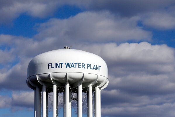 FILE - In this March 21, 2016 file photo, the Flint Water Plant water tower is seen in Flint, Mich. Prosecutors dropped all criminal charges Thursday, June 13, 2019, against eight people in the Flint water scandal and pledged to start the investigation from scratch. The defendants include Michigan's former health director, Nick Lyon, who was charged with involuntary manslaughter. He was accused of failing to timely alert the public about an outbreak of Legionnaires' disease that occurred in 2014-15 when Flint was drawing improperly treated water from the Flint River.  (AP Photo/Carlos Osorio, File)