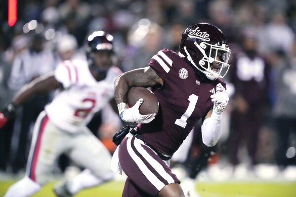 Mississippi State wide receiver Zavion Thomas (1) runs for a first down while being pursued by a Mississippi defender during the first half of an NCAA college football game in Starkville, Miss., Thursday, Nov. 23, 2023. (AP Photo/Rogelio V. Solis)