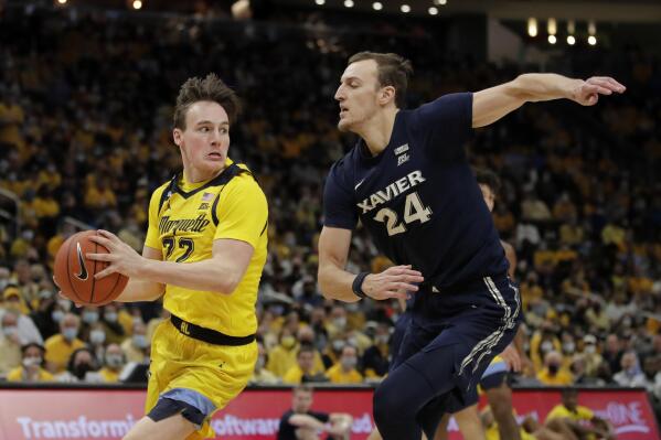 Marquette's Tyler Kolek looks to pass around Xavier's Jack Nunge (24) during the first half of an NCAA college basketball game, Sunday, Jan. 23, 2022, in Milwaukee. (AP Photo/Aaron Gash)