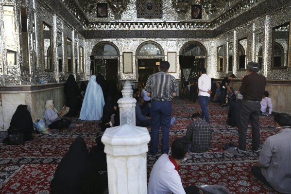 In this Saturday, June 13, 2020, photo, Muslim pilgrims pray outdoors at the shrine of the Saint Abdulazim in Shar-e-Ray, south of Tehran, Iran. Going inside is prohibited due the coronavirus. (AP Photo/Vahid Salemi)