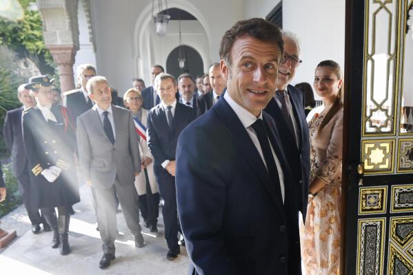 French President Emmanuel Macron, center, arrives to visit an exposition for the century commemoration of the Grande Mosquee of Paris opening, next to former French President Nicolas Sarkozy, second left, French Interior Minister Gerald Darmanin, third left, and Franco-Algerian lawyer and Rector of Paris' Grand Mosque Chems-eddine Hafiz, right, in Paris, Wednesday Oct. 19, 2022. (Ludovic Marin/Pool via AP)
