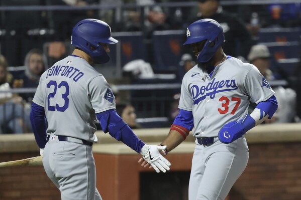 Los Angeles Dodgers' Teoscar Hernández, right, reacts after scoring on a single hit by Andy Pages with Michael Conforto, left, during the fifth inning of a baseball game against the New York Mets, Friday, May 23, 2025, in New York. (AP Photo/Pamela Smith)