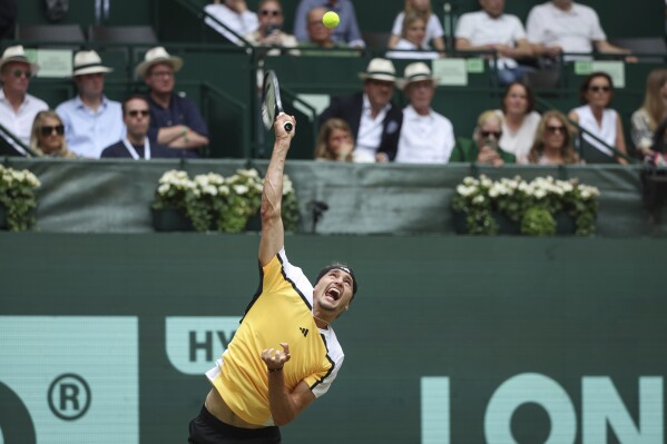 Germany's Alexander Zverev makes a serve against France's Arthur Fils during their quarter-finals ATP Tennis match in Halle, Germany, Friday June 21, 2024. (Friso Gentsch/dpa via AP)