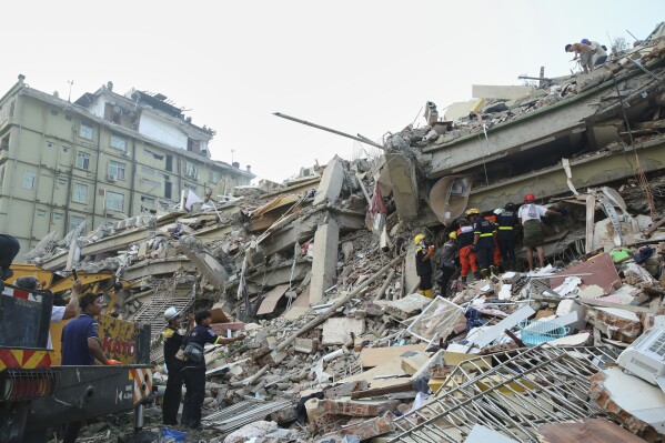In this photo released by Xinhua News Agency, rescuers conduct a search and rescue at a collapsed building in the aftermath of an earthquake in Mandalay, Myanmar, Sunday, March 30, 2025. (Myo Kyaw Soe/Xinhua via AP)