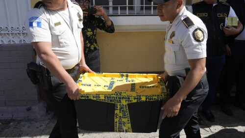 Police agents carry evidence collected from the Seed Movement political party headquarters, in Guatemala City, Friday, July 21, 2023. Guatemalan agents and police raided the offices of presidential candidate Bernardo Arevalo as part of an investigation into alleged wrongdoing in the party's formation. (AP Photo/Moises Castillo)