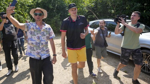Denver Nuggets center Nikola Jokic, center, arrives at the hippodrome in the northern Serbian town of Sombor, Sunday, June 18, 2023. Jokic came to Serbia after the Denver Nuggets won the NBA Championship with a victory over the Miami Heat in Game 5 of basketball's NBA Finals. (AP Photo/Darko Vojinovic)