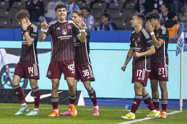 Nuremberg's Can Uzun, centre left, celebrates scoring a goal, during the Bundesliga second division soccer match between Hertha Berlin and Nuremberg, in Berlin, Saturday, March 30, 2024. One of Germany’s most exciting players isn’t even playing in the Bundesliga. Nuremberg teenager Can Uzun has 15 goals in the second division after scoring twice against Hertha Berlin this weekend. Only three players have more this season than the 18-year-old, whose performances have captured the attention of a host of clubs. (Andreas Gora/dpa via AP)