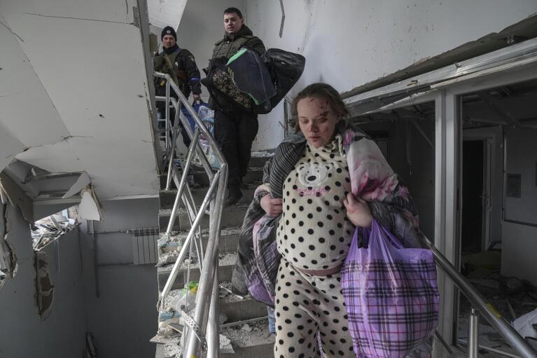 Mariana Vishegirskaya walks down stairs in a maternity hospital damaged by shelling in Mariupol, Ukraine, Wednesday, March 9, 2022. Vishegirskaya delivered her child the next day to the sound of shelling. (AP Photo/Evgeniy Maloletka)