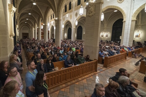 Mourners pack the Basilica of Saints Peter and Paul for a vigil for the victims of Wednesday's mass shootings, Sunday, Oct. 29, 2023, in Lewiston, Maine. (AP Photo/Robert F. Bukaty)
