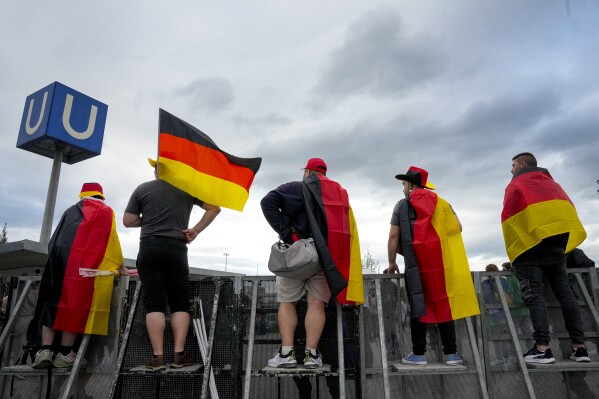 Germany's soccer team fans wave flags before a Group A match between Germany and Scotland at the Euro 2024 soccer tournament in Munich, Germany, Friday, June 14, 2024. (AP Photo/Markus Schreiber)