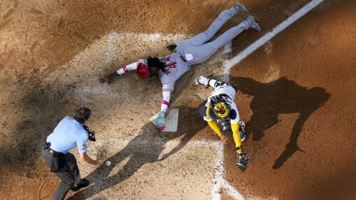 Cincinnati Reds' Elly De La Cruz steals home with Milwaukee Brewers catcher William Contreras covering during the seventh inning of a baseball game Saturday, July 8, 2023, in Milwaukee. (AP Photo/Morry Gash)