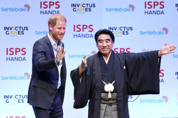 Britain's Prince Harry, escorted by Haruhisa Handa, CEO of the International Sports Promotion Society (ISPS), attends an event organized by the ISPS Wednesday, Aug. 9, 2023, in Tokyo. The program included topics such as the power of sport, community and philanthropy. Harry will travel to Singapore to play in the Sentebale ISPS Handa Polo Cup on Aug. 12. (AP Photo/Eugene Hoshiko)