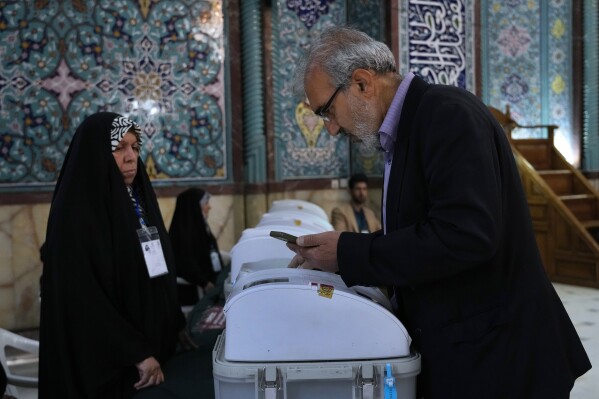 An Iranian man votes for the parliamentary runoff elections at a polling station in Tehran, Iran, Friday, May 10, 2024. Iranians voted Friday in a runoff election for the remaining seats in the country's parliament after hard-line politicians dominated March balloting. (Ǻ Photo/Vahid Salemi)