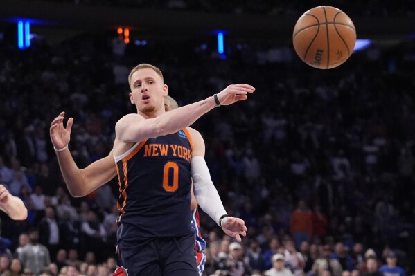 New York Knicks' Donte DiVincenzo (0) passes the ball to teammate Jalen Brunson during the second half of Game 2 in an NBA basketball first-round playoff series against the Philadelphia 76ers Monday, April 22, 2024, in New York. (AP Photo/Frank Franklin II)
