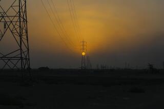 FILE - The sun sets behind the transmission lines of electric power from Iran to Iraq in Basra, Iraq, July 29, 2021.  In a statement Wednesday, June 1, 2022, Iraq's Electricity Ministry said the country will face power shortages after crucial energy supplies from Iran were cut over non-payment. (AP Photo/Nabil al-Jurani File)