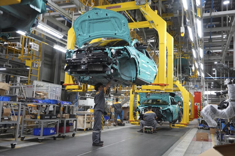 FILE - Workers assemble electric cars at a Vinfast factory in Hai Phong, Vietnam, on Sept. 29, 2023. Amid an ongoing push to make transportation less damaging to the climate, electrification continued to accelerate in 2023, with one in five cars sold across the globe this year expected to be electric, according to the International Energy Industry. (AP Photo/Hau Dinh)