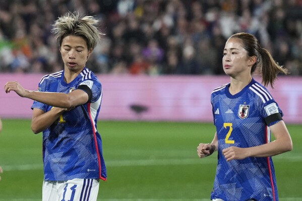 Japan's Risa Shimizu, left, adjusts her black arm band as she runs with teammate Japan's Risa Shimizu prior to the start of the Women's World Cup Group C soccer match between Zambia and Japan in Hamilton, New Zealand, Saturday, July 22, 2023. (AP Photo/John Cowpland)