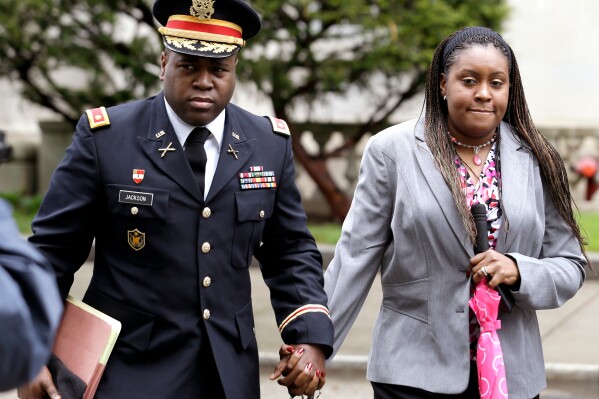 FILE - In this May 9, 2013, file photo, John Jackson, left, and his wife, Carolyn Jackson, of Mount Holly, N.J., walk out of a courthouse in Newark, N.J. Carolyn Jackson was ordered Monday, Oct. 30, to serve nearly 12 years in prison, while her husband, John, was sentenced to 9 years. (AP Photo/Julio Cortez, File)