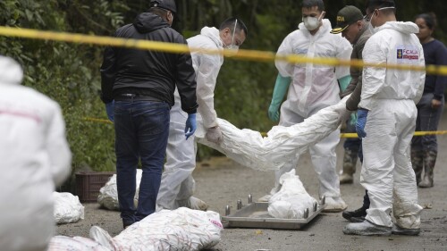 Forensics collect the wrapped bodies of victims of an avalanche that smothered their homes overnight, in El Naranjal, Colombia, Tuesday, July 18, 2023. (AP Photo/Fernando Vergara)