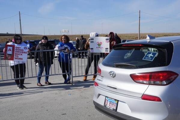 People protest ride-hailing companies like Uber, Lyft and others in the Transportation Network Provider parking lot at O'Hare International Airport, Wednesday, Feb. 14, 2024, in Chicago. (AP Photo/Erin Hooley)