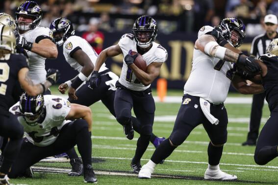 Baltimore Ravens running back Kenyan Drake, center, runs with the ball in the first half of an NFL football game against the New Orleans Saints in New Orleans, Monday, Nov. 7, 2022. (AP Photo/Butch Dill)