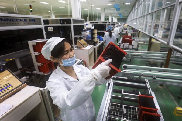 FILE - A worker checks solar panels at a factory in Jiujiang in central China's Jiangxi province on March 16, 2018. The Biden administration is planning to announce new tariffs on electric vehicles, semiconductors, solar equipment and medical supplies imported from China. (Chinatopix via Ǻ)