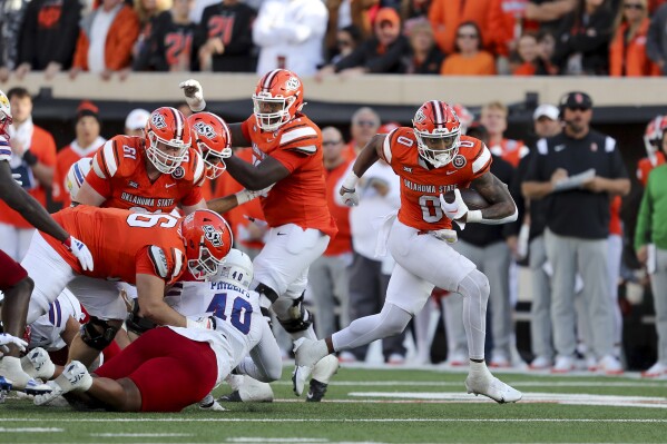 Oklahoma State's Ollie Gordon II (0) runs the ball during the second half of an NCAA college football game against Kansas in Stillwater, Okla., Saturday, Oct. 14, 2023. (AP Photo/Mitch Alcala)