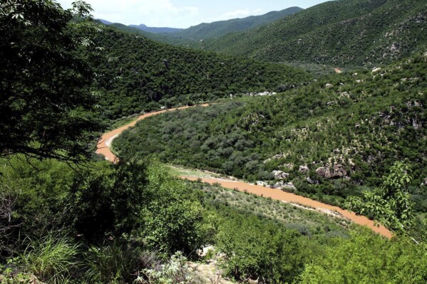 FILE - the Sonora River, contaminated by the spill of about 10 million gallons of copper sulfate and heavy metals from the Buenavista copper mine, makes its way through the hills near the town of Mazocahui in the northern state of Sonora, Mexico, Aug. 12, 2014. Residents in Mexico’s northern state of Sonora protested Tuesday, Dec. 5, 2023, against what they said is the government’s continued failure to clean up an almost decade-old mine spill. (APPhoto/El Imparcial, Julian Ortega, File)