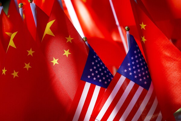 American flags are displayed together with Chinese flags on top of a trishaw on Sept. 16, 2018, in Beijing. (AP Photo/Andy Wong, File)