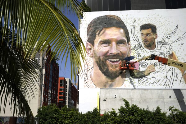 Artist Maximiliano Bagnasco paints a mural of Argentine soccer star Lionel Messi, Monday, July 10, 2023, in the Wynwood neighborhood of Miami. Murals, burgers, beers, and billboards are just a handful of examples that show the euphoria that Messi generates in South Florida and how he will be received when he lands for his new stage as a player with the Major League Soccer team Inter Miami. (AP Photo/Lynne Sladky)