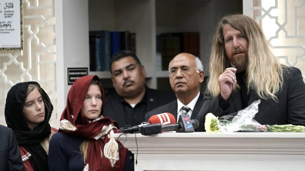 
              Jason Cogburn, right, speaks as his wife, Joleen, left, and daughter, Jaelyn, far left, listen during a funeral for Pakistani exchange student Sabika Sheikh, who was killed in the Santa Fe High School shooting, during a service at the Brand Lane Islamic Center Sunday, May 20, 2018, in Stafford, Texas. A gunman opened fire inside Santa Fe High School Friday, May 18, 2018, killing mu;tiple people. The Cogburns were the host family for Sheikh. (AP Photo/David J. Phillip)
            