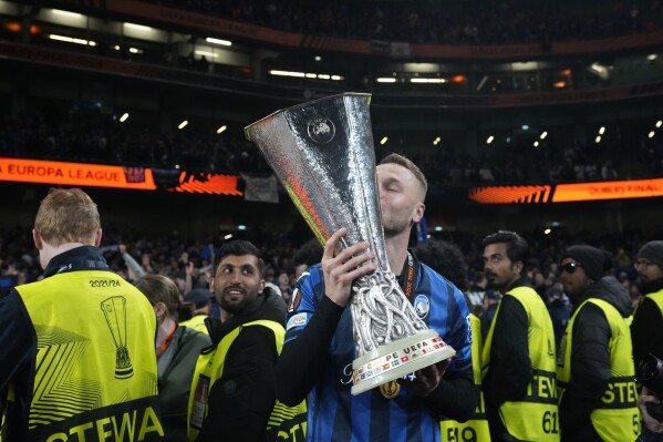 Atalanta's Teun Koopmeiners celebrates with Europa League trophy at the end of the Europa League final soccer match between Atalanta and Bayer Leverkusen at the Aviva Stadium in Dublin, Ireland, Thursday, May 23, 2024. Atlanta won 3-0. (AP Photo/Frank Augstein)
