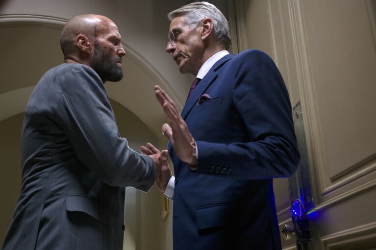 This image released by Amazon MGM Studios shows Jason Statham, left, and Jeremy Irons in a scene from "The Beekeeper." (Amazon MGM Studios via AP)