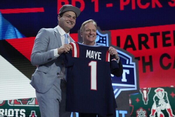 North Carolina quarterback Drake Maye poses with NFL commissioner Roger Goodell after being chosen by the New England Patriots with the third overall pick during the first round of the NFL football draft, Thursday, April 25, 2024, in Detroit. (AP Photo/Jeff Roberson)