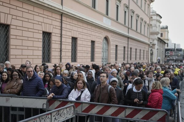 People wait in line to view Pope Francis lying in state inside St. Peter's Basilica, at the Vatican, Thursday, April 24, 2025. (AP Photo/Markus Schreiber)
