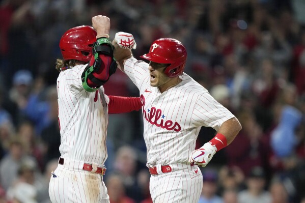 Philadelphia Phillies' J.T. Realmuto, right, and Bryce Harper celebrate after Realmuto's three-run home run during the sixth inning of a baseball game against the New York Mets, Friday, Sept. 22, 2023, in Philadelphia. (AP Photo/Matt Slocum)