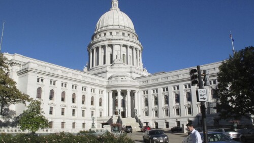 FILE - A man walks by the Wisconsin state Capitol, Oct. 10, 2012, in Madison, Wis. The Wisconsin Assembly is scheduled to vote Wednesday, June 21, 2023, on a Republican-authored, bipartisan bill opposed by anti-abortion groups that would allow pharmacists to prescribe and dispense birth control. (AP Photo/Scott Bauer, File)