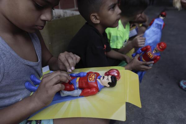Children play with "Super Bigote" dolls in the Carayaca neighborhood of La Guaira , Venezuela, Tuesday, Dec. 27, 2022. The delivery of toys of "Super Bigote" or Super Mustache and "Cilita" dolls based on the image of Venezuelan President Nicolas Maduro and his wife Cilia Flores, were handed to thousands of children this Christmas, causing controversy among some Venezuelans. (AP Photo/Jesus Vargas)