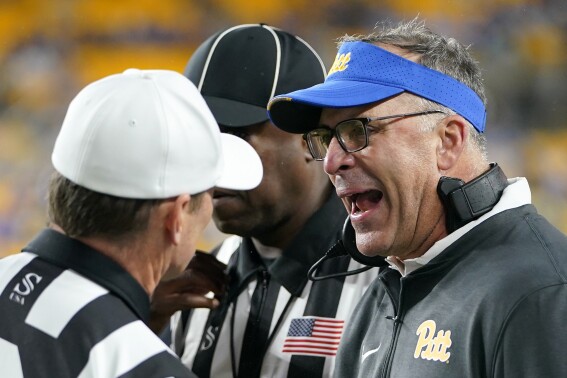 Pittsburgh head coach Pat Narduzzi, right, questions referee Stuart Mullins, left, during the first half of an NCAA college football game against North Carolina in Pittsburgh, Saturday, Sept. 23, 2023. (AP Photo/Gene J. Puskar)