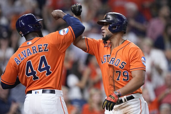 Tampa Bay Rays' Randy Arozarena is congratulated by teammates after scoring  the in the ninth inning of a baseball game against the Cleveland Indians,  Friday, July 23, 2021, in Cleveland. (AP Photo/Tony