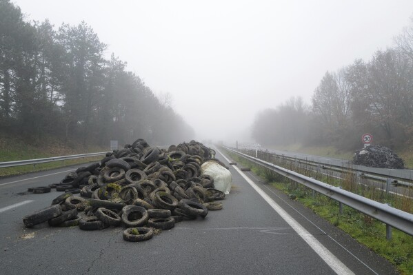 Tyres lie on the highway during a blockade, near Agen, southwestern France, Saturday, Jan. 27, 2024. French farmers have vowed to continue protesting and are maintaining traffic barricades on some of the country's major roads. The government announced a series of measures Friday but the farmers say these do not fully address their demands. (AP Photo/Fred Scheiber)