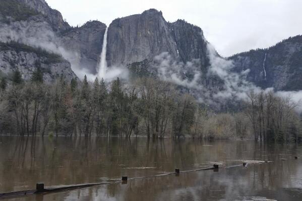 FILE - In this photo released by the National Park Service, floodwaters cover Cooks Meadow and the pedestrian trail through Cooks Meadow in Yosemite Valley in Yosemite, Calif., on April 7, 2018. Much of the famed valley at park will be temporarily closed starting Friday due to a forecast of flooding as rising temperatures melt the Sierra Nevada's massive snowpack. Park officials said Tuesday, April25, 2023, that the eastern section of Yosemite Valley will stay closed at least until May 3. (National Park Service via AP, File)