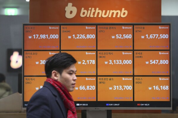 FILE - A man passes by a screen showing the prices of bitcoin at a virtual currency exchange office in Seoul, South Korea, Tuesday, Jan. 16, 2018. When cryptocurrencies collapsed and companies failed last year, Congress considered multiple approaches for how to regulate cryptocurrencies in the future. However, most of those efforts have gone nowhere, especially in this chaotic year that has been dominated by geopolitical tensions, inflation and the upcoming 2024 election. (AP Photo/Ahn Young-joon, File)